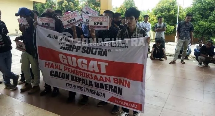 DEMO KPU - Mahasiswa yang tergabung dalam Aliansi Mahasiswa Peduli Pilkada (AMPP) berunjuk rasa di Sekretariat KPU Sulawesi Tenggara (Sultra), Selasa (11/10/2016). AMPP mendesak transparansi hasil tes narkoba 7 daerah pemilihan kepela daerah (Pilkada) 2017. (Muhamad Taslim Dalma/ZONASULTRA.COM)
