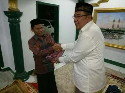Wali Kota Kendari Asrun menyerahkan Mushaf Al Quran kepada pengelolah Masjid Umushabri yang diterima langsung oleh ketua pengurus masjid.