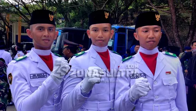 Petugas pengerek bendera Dwi Wahyu Nurcahyo siswa SMA Negeri 1 Kendari (kiri) pembentang bendera, Laode Al Wahid (tengah) dan Aditya Dwi Bagida (kanan).