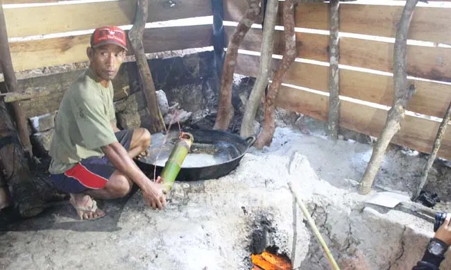 f1 PENYADAP GULA AREN- Awaludin pria berusia (35) tahun warga Desa Tangkeno, Kecamatan Kabaena Tengah saat sedang memasak air nira untuk dibuat menjadi gula aren, Jumat (26/8/2016). Kegiatan ini telah menjadi mata pencaharian dirinya selama kurang lebih 20 tahun terkahir.(ILHAM SURAHMIN/ZONASULTRA.COM)