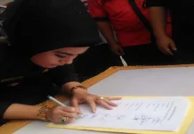 Bupati Himbau PNS Bombana Jadi Pemilih Profesional Bupati Bombana, Hj. Sitti Saleha saat menandatangani naskah deklarasi damai di podium RTH Bombana, Jum'at (28/10/2016). (Jumrad Raunde/ZONASULTRA.COM)