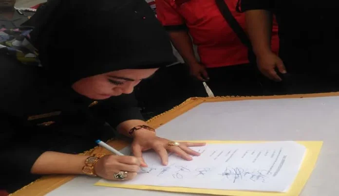Bupati Bombana, Hj. Sitti Saleha saat menandatangani naskah deklarasi damai di podium RTH Bombana, Jum'at (28/10/2016). (Jumrad Raunde/ZONASULTRA.COM)