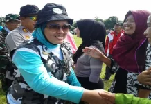 Bupati Konut Serahkan Bantuan PKH pada Warga Desa Linomoio PEMBAGIAN KARTU PKH- Terlihat Kepala Dinas Kesehatan Kabupaten Konawe Utara (Konut), Nurjannah Efendi menyalurkan kartu program keluarga harapan (PKH) kepada masyarakat miskin di Desa Linomoio, Kecamatan Oheo dala kegiatan gerak jalan napak tilas dalam mempringati hari pahlawan. (Jefri/ZONASULTRA.COM).