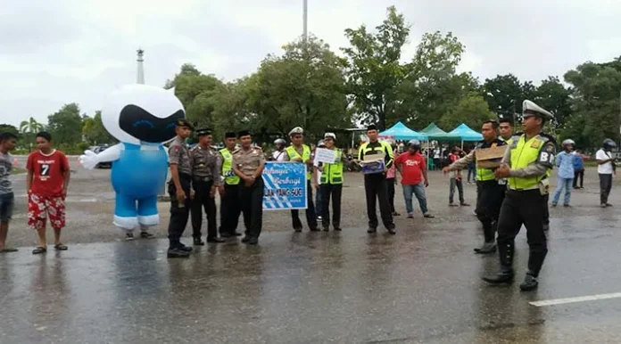 BAGI TAKJIL - Kapolres Muna AKBP. Agung Ramos Paretongan Sinaga berserta Wakapolres, Kasatlantas dan seluruh anggota Satlantas Polres Muna saat membagikan takjil kepada masyarakat pengguna jalan di depan Tugu Jati Kota Raha, Minggu (4/6/2017). (Kasman/ZONASULTRA.COM)