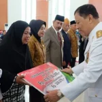 Plt Gubernur Sultra Serahkan Santunan BPJS Ketenagakerjaan Rp 584,7 Juta pada Ahli Waris BPJS KETENAGAKERJAAN - Pelaksana tugas (plt) Gubernur Sultra Saleh Lasata saat menyerahkan secara simbolis kepada penerima ahli waris peserta BPJS Ketenagakerjaan sebesar Rp. 418 juta yang didampingi Kepala Cabang BPJS Ketenagakerjaan La Uno (kanan), Kamis (17/8/2017). (ILHAM SURAHMIN/ZONASULTRA.COM)