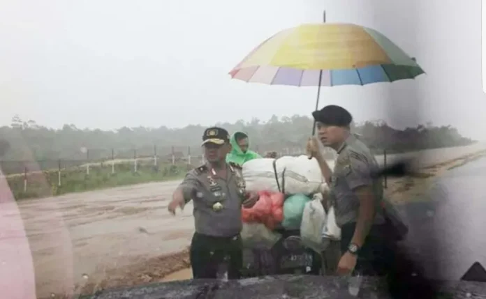 Foto Kapolda Sultra Bantu Pengendara Motor Kehujanan Viral di Sosmed