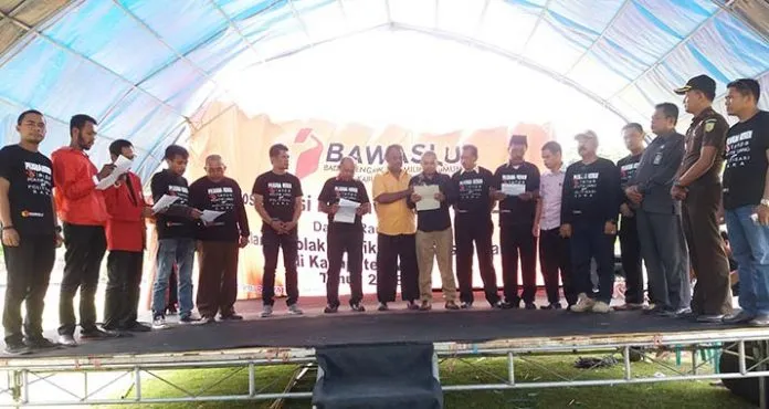 DEKLARASI- Ketua Panwaslu Muna Al Abzal Naim bersama Kapolres Muna AKBP Agung Ramos Paretongan Sinaga, Kejari Muna yang diwakili oleh Yoseptus Ary Sepyandoko, perwakilan partai politik dan perwakilan masyarakat saat membacakan naskah deklarasi menolak dan melawan politik uang dan politisasi SARA pada pilkada serentak 2018, yang dilaksanakan di Alun-alun Kota Raha, Rabu (14/2/2018).(Kasman/ZONASULTRA.COM)