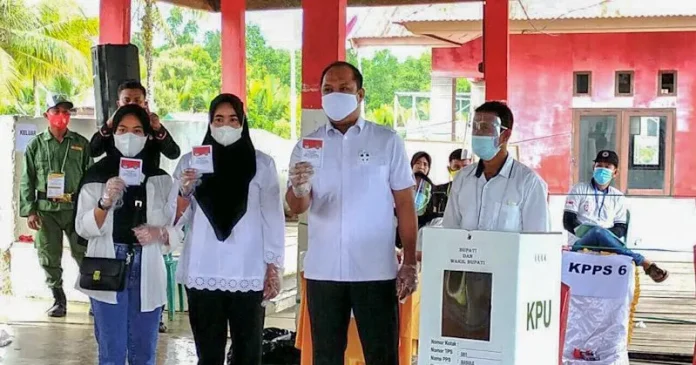 Ruksamin Didampingi Istri dan Anak Mencoblos di TPS 1 Desa Basule