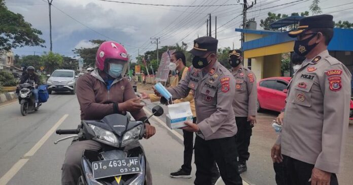 Polsek Baruga Gandeng Mahasiswa Bagi-bagi Masker Gratis