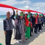 7.000 Masyarakat Konut Kirab Bendara Sepanjang 7,8 Km di Pantai Taipa 7.000 Masyarakat Konut Kirab Bendara Sepanjang 7,8 Km di Pantai Taipa